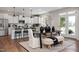 Modern kitchen with white cabinets, stainless steel appliances, an island with seating, and elegant dining area at 456 Golden Dragonfly St, Wake Forest, NC 27587