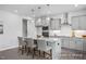 This kitchen features light gray cabinets, stainless appliances and a large island with seating and granite countertops at 456 Golden Dragonfly St, Wake Forest, NC 27587