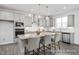 Bright kitchen boasts gray cabinets, stainless appliances, granite countertops and island with pendant lights at 456 Golden Dragonfly St, Wake Forest, NC 27587