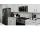 Close-up of a kitchen featuring stainless steel appliances, white cabinetry, and subway tile backsplash at 456 Golden Dragonfly St, Wake Forest, NC 27587