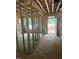 Unfinished room displaying exposed framing, insulation, and an exterior door with backyard access at 456 Golden Dragonfly St, Wake Forest, NC 27587