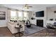 Cozy living room featuring a modern fireplace, plush sofa, neutral decor, and large windows at 456 Golden Dragonfly St, Wake Forest, NC 27587