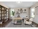 Stylish home office featuring a light wood desk, unique decor, neutral tones, and ample natural light at 456 Golden Dragonfly St, Wake Forest, NC 27587
