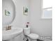 Stylish powder room featuring a pedestal sink, decorative mirror, and a small window at 456 Golden Dragonfly St, Wake Forest, NC 27587