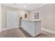 Basement bar with white cabinets, granite countertop, stainless steel sink, and door at 4817 Fox Branch Ct, Raleigh, NC 27614
