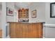 Wooden bar with marble countertop and glass door cabinets at 4817 Fox Branch Ct, Raleigh, NC 27614