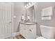 Bathroom featuring toilet, vanity with white cabinets, sink, neutral-toned walls, and black and white floor at 4817 Fox Branch Ct, Raleigh, NC 27614