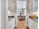 Butler's pantry with granite countertops, white cabinets and an opening to the dining room at 4817 Fox Branch Ct, Raleigh, NC 27614