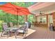 Relaxing deck featuring wooden table, chairs, brick columns, fan, grill, and serene tree views at 4817 Fox Branch Ct, Raleigh, NC 27614