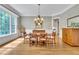 Formal dining room with wood floors, wainscoting, chandelier, and large window with natural light at 4817 Fox Branch Ct, Raleigh, NC 27614