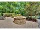 Outdoor stone fire pit surrounded by a paved patio and lush landscaping, perfect for gatherings at 4817 Fox Branch Ct, Raleigh, NC 27614