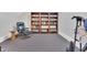 Home gym with workout chair, bookshelf, and carpeted floor, creates a functional fitness area at 4817 Fox Branch Ct, Raleigh, NC 27614