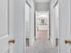 Hallway view into a bathroom with white cabinets and neutral tones at 4817 Fox Branch Ct, Raleigh, NC 27614