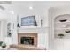 Elegant living room featuring a brick fireplace and built-in bookshelves with decorative accents at 4817 Fox Branch Ct, Raleigh, NC 27614