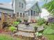 A backyard area featuring a stone patio with outdoor seating and lush garden surroundings at 5720 Brushy Meadows Dr, Fuquay Varina, NC 27526