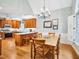 Open concept kitchen and dining room with island, wood cabinets, chandelier, and hardwood floors at 5720 Brushy Meadows Dr, Fuquay Varina, NC 27526