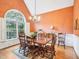 Inviting dining room with wood table and chairs beneath a bright chandelier and arched window at 5720 Brushy Meadows Dr, Fuquay Varina, NC 27526