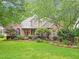 Traditional home with lush landscaping, mature trees, and a well-maintained lawn at 5720 Brushy Meadows Dr, Fuquay Varina, NC 27526