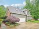 Exterior of a two-car garage connected to the house, surrounded by landscaped plants and green grass at 5720 Brushy Meadows Dr, Fuquay Varina, NC 27526