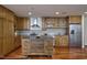 Stylish kitchen with wood cabinets, an island with seating, and stainless steel appliances, showcasing a modern design at 601 W Rosemary St # 712, Chapel Hill, NC 27516