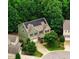 Aerial view of a green two story home with solar panels surrounded by lush trees at 62 Jubilee Ct, Clayton, NC 27527