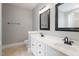 A gray bathroom with dual sinks, framed mirrors, and a tile floor at 6335 Cedar Waters Dr, Raleigh, NC 27607