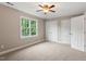 A carpeted bedroom with a ceiling fan, a double window, and two closets at 6335 Cedar Waters Dr, Raleigh, NC 27607