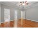 A neutral-colored bedroom with hardwood floors, a trey ceiling, and entrances to a bathroom and walk-in closet at 6335 Cedar Waters Dr, Raleigh, NC 27607