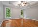 A neutral-colored bedroom with hardwood floors, a trey ceiling, a ceiling fan and large windows at 6335 Cedar Waters Dr, Raleigh, NC 27607