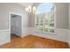 Elegant dining room with hardwood floors, wainscoting, chandelier, and a large window at 6335 Cedar Waters Dr, Raleigh, NC 27607