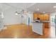 Bright open-concept living room featuring hardwood floors, a ceiling fan, and views to the kitchen and second-floor overlook at 6335 Cedar Waters Dr, Raleigh, NC 27607