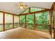 Large screened-in porch with a ceiling fan, view of the trees, and wooden floors at 6335 Cedar Waters Dr, Raleigh, NC 27607