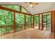 Large screened-in porch with wooden floors and a ceiling fan overlooking a green backyard at 6335 Cedar Waters Dr, Raleigh, NC 27607