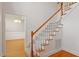 Carpeted staircase with wooden banister leading to an open foyer and hardwood floors at 6335 Cedar Waters Dr, Raleigh, NC 27607