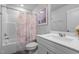 Clean bathroom with a tub-shower, a patterned shower curtain, a white vanity with mirror and sink at 6352 Perry Creek Rd, Raleigh, NC 27616