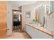 Well-lit bathroom featuring a single vanity, white cabinets, and a view into the bedroom at 6412 Heartwood Dr, Chapel Hill, NC 27516