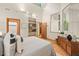 Bright bedroom featuring hardwood floors, bookshelves, and a large mirror reflecting natural light at 6412 Heartwood Dr, Chapel Hill, NC 27516