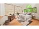Comfortable bedroom with large windows showcasing wooded views and modern decor at 6412 Heartwood Dr, Chapel Hill, NC 27516