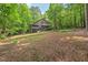 Rear exterior and yard featuring mature trees and landscaping at 6412 Heartwood Dr, Chapel Hill, NC 27516