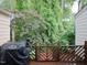 View of wooded backyard from wood back deck with grilling equipment at 6756 Olde Province Ct, Raleigh, NC 27609