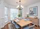 Bright dining area featuring wainscoting, a chandelier and a large window at 6756 Olde Province Ct, Raleigh, NC 27609