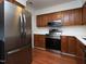 Kitchen features stainless steel refrigerator, microwave, and range with oak cabinets at 6756 Olde Province Ct, Raleigh, NC 27609