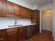 This kitchen is equipped with stainless steel appliances and oak cabinets and laminate flooring at 6756 Olde Province Ct, Raleigh, NC 27609