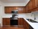 Well-lit kitchen features stainless steel appliances, wooden cabinets and bright white countertops at 6756 Olde Province Ct, Raleigh, NC 27609
