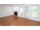 An empty living room with hardwood floors, fireplace and patio door leading to back yard at 6756 Olde Province Ct, Raleigh, NC 27609