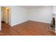 Empty living room features a fireplace, hardwood floors, and door leading to hallway at 6756 Olde Province Ct, Raleigh, NC 27609