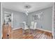 Dining area boasts hardwood floors, modern lighting, a glass table set, and stylish wall decor at 6828 Edwell Ct, Raleigh, NC 27617