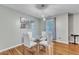 Dining area boasts hardwood floors, modern lighting, a glass table set, and stylish wall decor at 6828 Edwell Ct, Raleigh, NC 27617