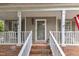 Inviting front porch features classic railings, neutral siding, and a stylish entrance with decorative details at 6828 Edwell Ct, Raleigh, NC 27617