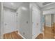 Hallway showcases wood floors, neutral walls, and white doors leading to various rooms, creating a seamless flow at 6828 Edwell Ct, Raleigh, NC 27617